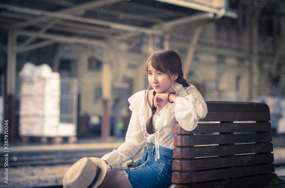 Fototapeta premium young woman sitting on the train station in the city