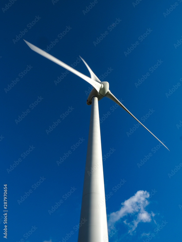 White wind turbine against a blue sky White wind turbine against a blue sky