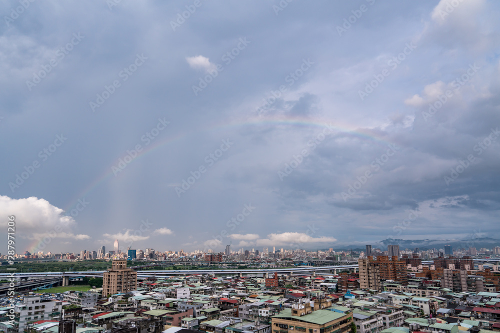 Skyline of taipei city in downtown Taipei, Taiwan.bright sun shining center top and a large rainbow arcing from left to right