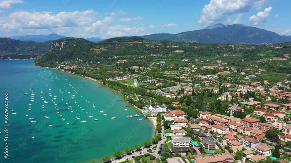 Aerial video with drone. Beautiful coastline. In the city of Bardolino, Lake Garda is the north of Italy. View by Drone. Docked yachts parking in Port. Aerial video with drone. Beautiful coastline. In the city of Bardolino, Lake Garda is the north of Italy. View by Drone. Docked yachts parking in Port.