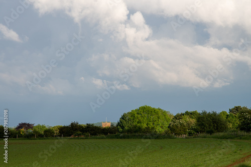 Storm clouds building over green fields and trees on a summer day in the countryside near Shenington, Oxfordshire