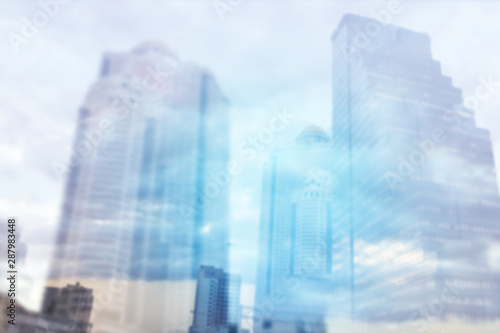 Abstract Blurred background, Double exposure of business Skyscraper with sunrise and sky clouds, business and finance background concept © Tanakorn