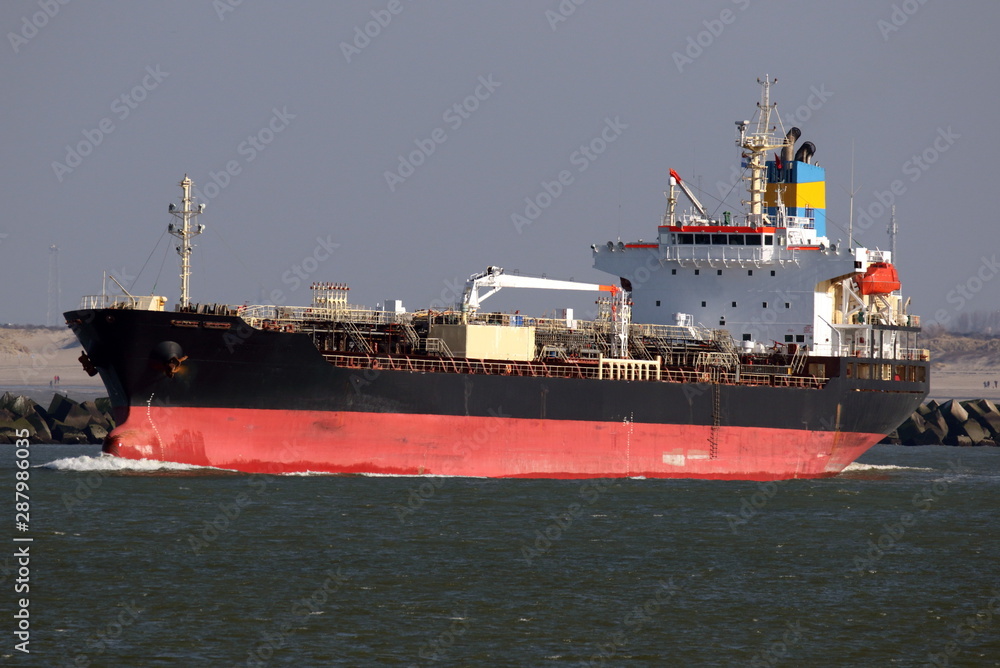 schwarzer Tanker verlässt bei schönem Wetter den Hafen