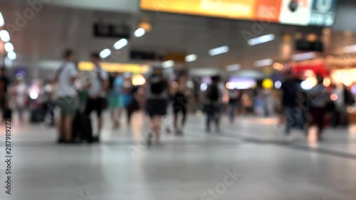 Unidentified passengers with things in large European train station. 4K. Blurred view