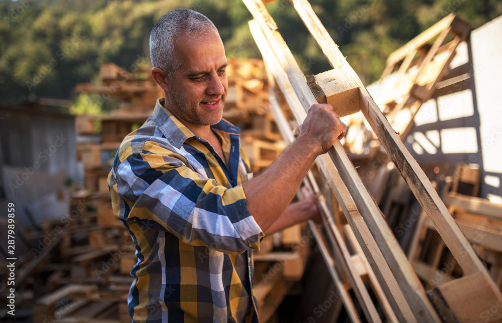 a carpenter repairs wooden pallets a carpenter repairs wooden pallets