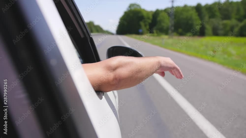 Man puts his hand out car window, feels the fresh air, on a sunny day. Close up shot. Man puts his hand out car window, feels the fresh air, on a sunny day. Close up shot.