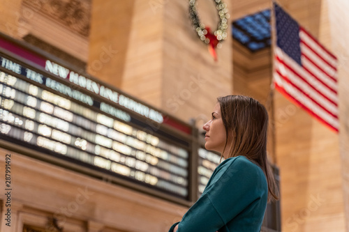 woman checking the train timetable in the grand central terminal in new york