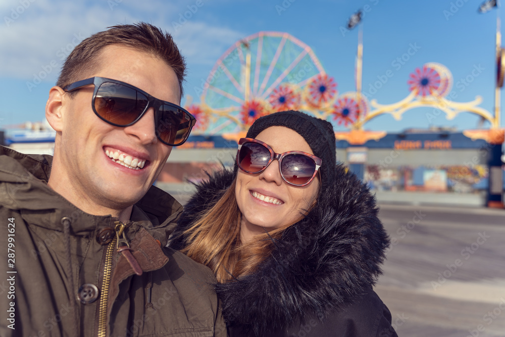 couple taking a selfie in coney island. Luna park as background couple taking a selfie in coney island. Luna park as background