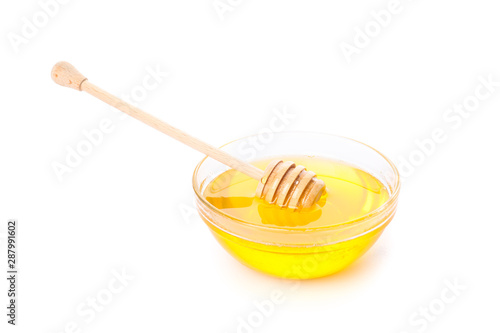 Dipper and honey in glass bowl isolated on white background