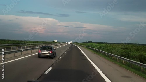 FPV: Driving along the highway. View of the road from the car window. Cars go to a meeting. photo