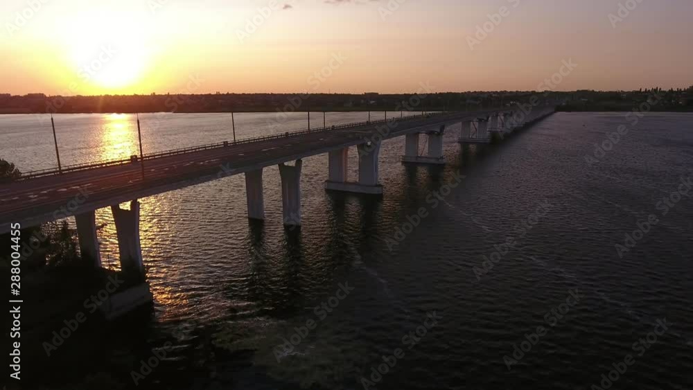 Aerial shot of a straight bridge at sunset from a drone moving along in summer Aerial shot of a straight bridge at sunset from a drone moving along in summer
