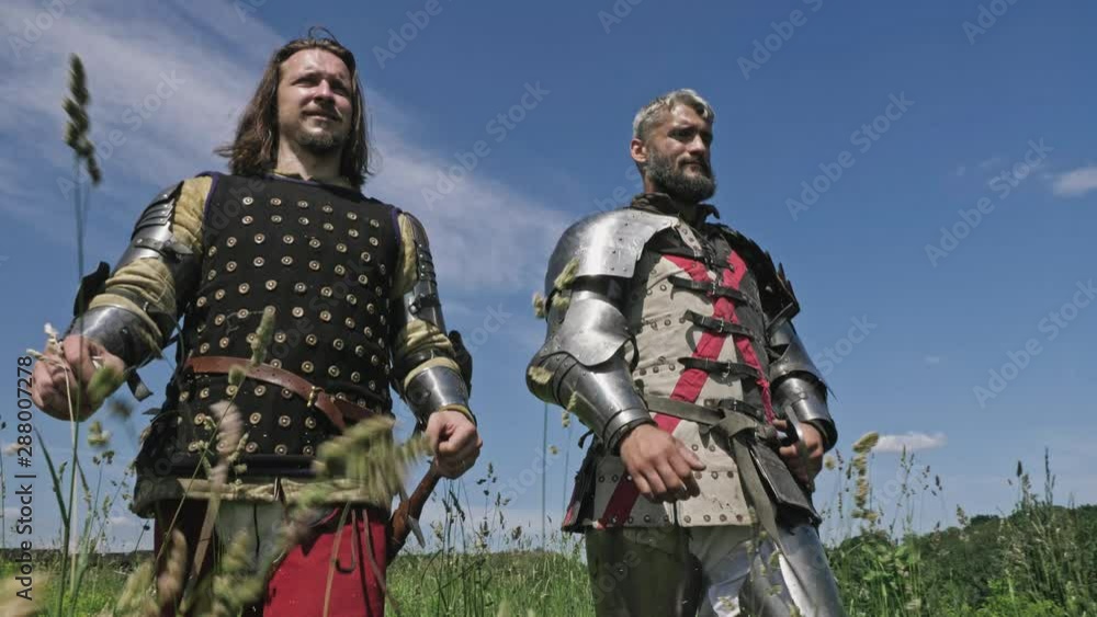 Medieval knights going against blue sky. Knights wearing traditional steel armor. Medieval knights going against blue sky. Knights wearing traditional steel armor.