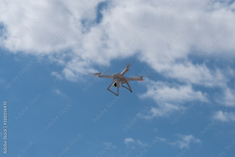 Drone, copter is flying in the blue sky. Modern video and aerial photography