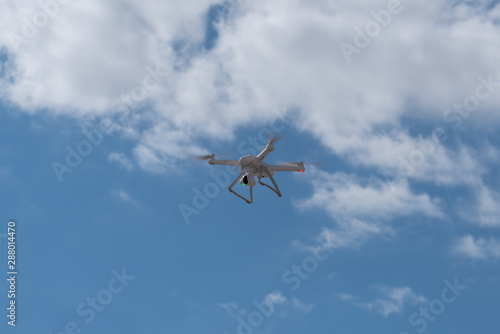 Drone, copter is flying in the blue sky. Modern video and aerial photography