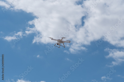Quadcopter, drone, copter is flying in the blue sky. Modern video and aerial photography