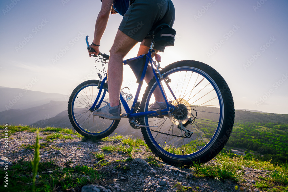 Close up photo from a mountain biker riding his bike ( bicycle) on rough rocky terrain on top of a mountain, wearing no safety equipment. Adrenalin junkie. Close up photo from a mountain biker riding his bike ( bicycle) on rough rocky terrain on top of a mountain, wearing no safety equipment. Adrenalin junkie.