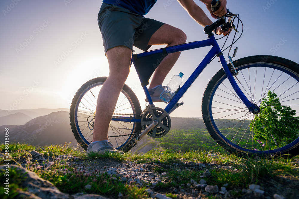 Close up photo from a mountain biker riding his bike ( bicycle) on rough rocky terrain on top of a mountain, wearing no safety equipment. Adrenalin junkie. Close up photo from a mountain biker riding his bike ( bicycle) on rough rocky terrain on top of a mountain, wearing no safety equipment. Adrenalin junkie.