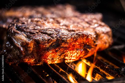 Grilled ancho steak on barbecue grill with fire. BBQ Steak ancho meat steak