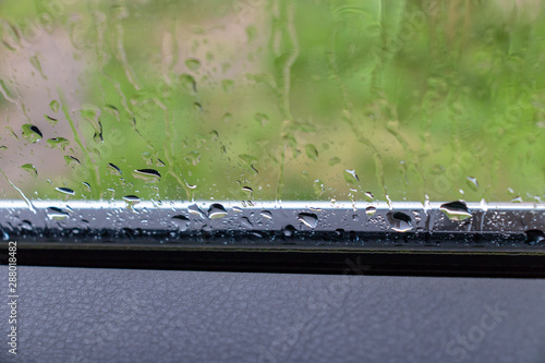 Rain drops on car glass in rainy day, summer is over and autumn fall storms and bad weather comes