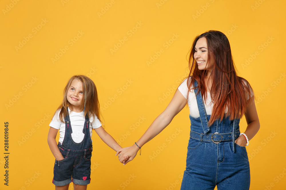 Woman in light clothes have fun with cute child baby girl 4-5 years old. Mommy little kid daughter isolated on yellow background studio portrait. Mother's Day love family parenthood childhood concept.
