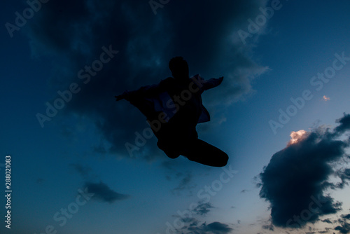 Silhouette of excited male dancer leaping at the sky © qunica.com