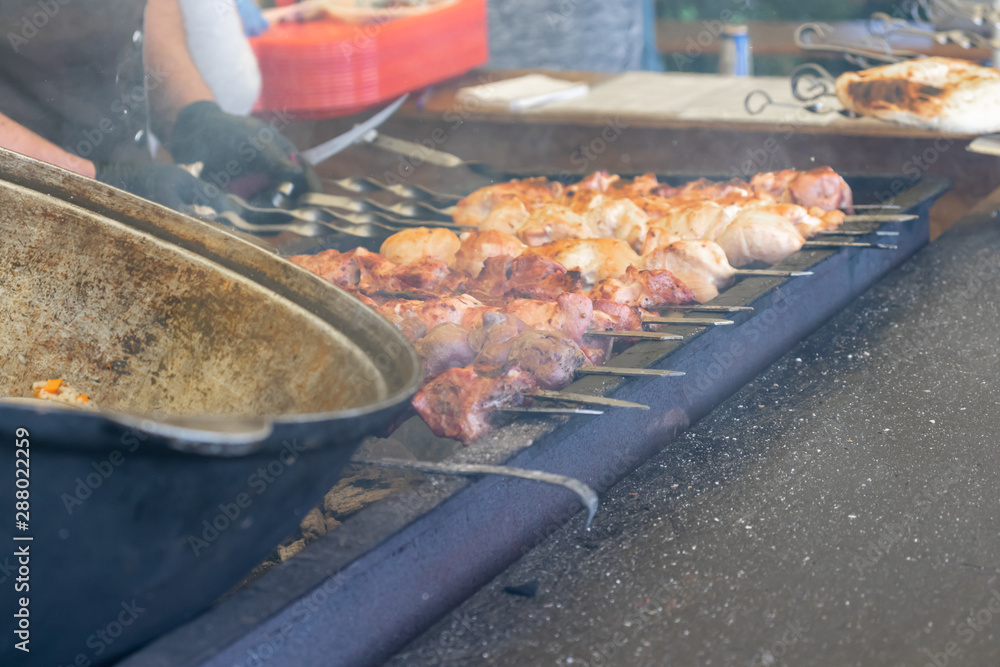 Street food, barbecuing on a hot grill with fire and smoke, vegetables and meat cooked for taking out