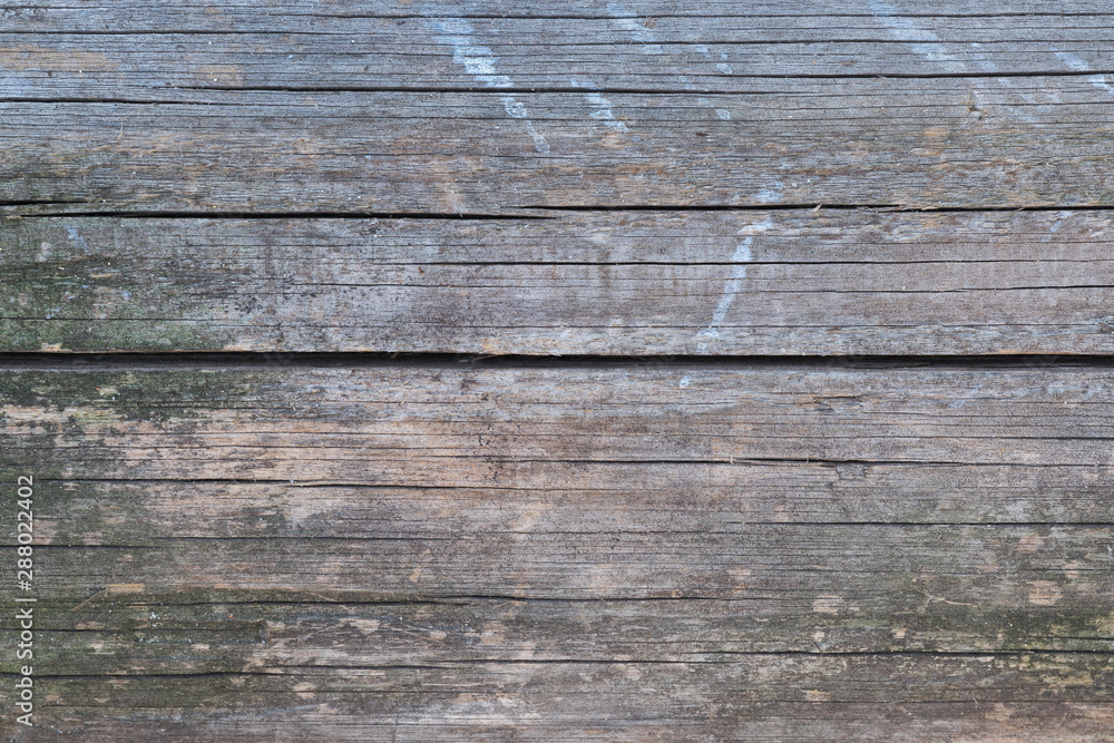 Old gray-brown natural wood background in the form of a board with cracks, knots and a rough surface Old gray-brown natural wood background in the form of a board with cracks, knots and a rough surface