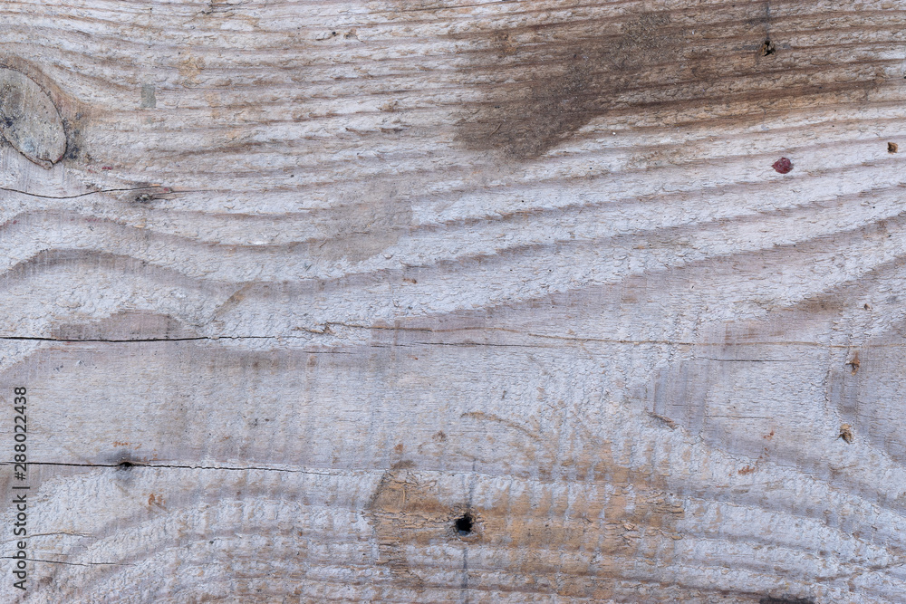 Fototapeta premium Old gray-brown natural wood background in the form of a board with cracks, knots and a rough surface