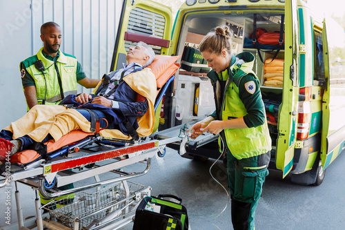 Paramedics giving medical treatment to patient outside ambulance