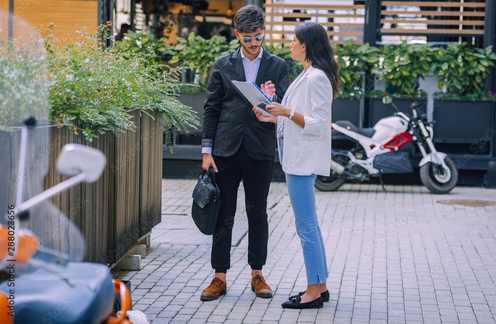 Obraz premium Businessman and businesswoman talking in the front of the office building