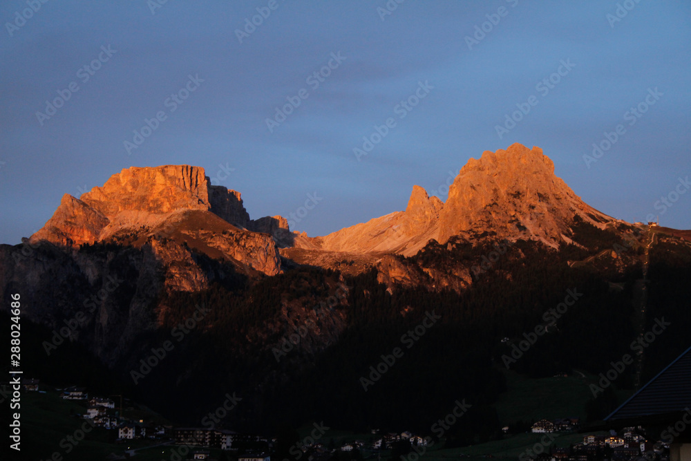 Sundown in the Dolomites above Selva di Val Gardena, Red and Orange glow on the Cirspitzen in Gröden