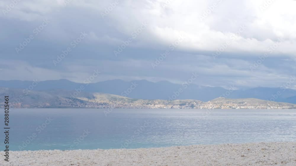 Time lapse, cloudy sky over blue ocean and coastline seascape with hills in the background. Time lapse, cloudy sky over blue ocean and coastline seascape with hills in the background.