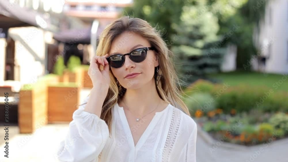 30s aged woman in white blouse taking off sunglasses. Slow motion 30s aged woman in white blouse taking off sunglasses. Slow motion