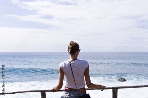 A blonde girl is looking the Atlantic Ocean (Madeira, Portugal)