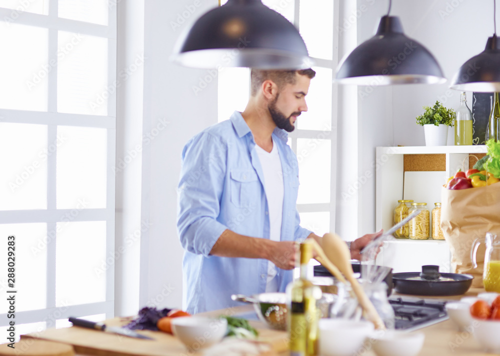 Smiling and confident chef standing in large kitchen Smiling and confident chef standing in large kitchen