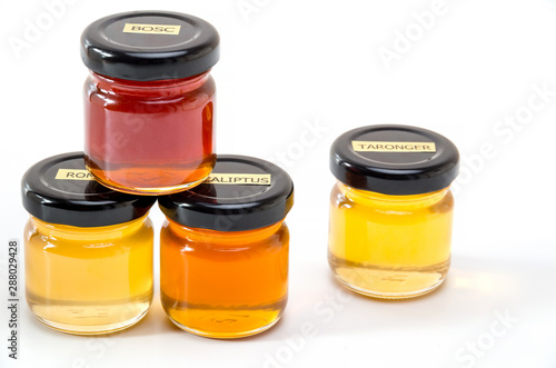 Jars with honey with labels on white background
