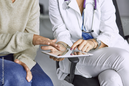 female doctor talking to a patient on a tablet