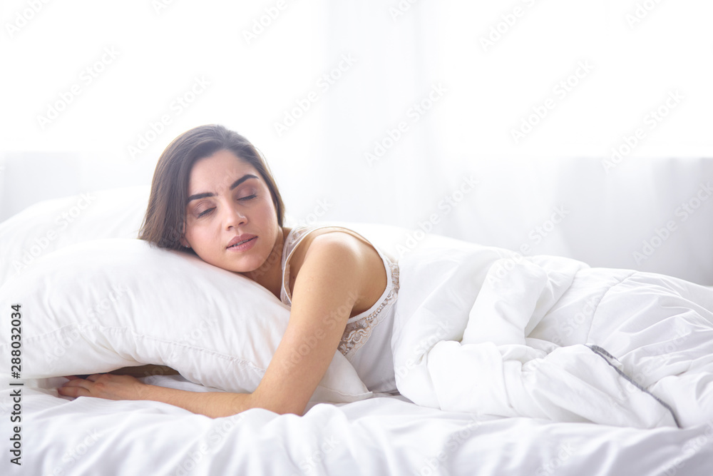 beautiful young woman basking in bed in the morning. Beautiful beautiful young woman basking in bed in the morning. Beautiful