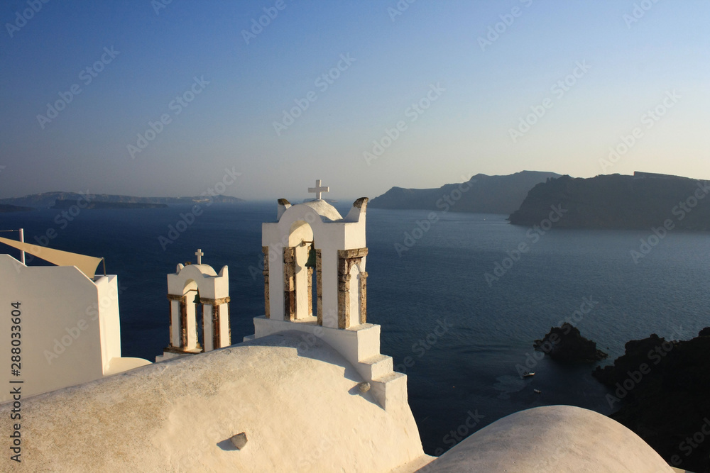 Oia, Santorini - view of the church bell towers, in the background the sea and islands