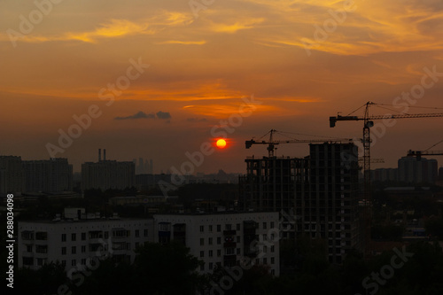 Crane and building construction site at sunset