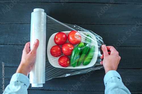 Foto Using food film for vegetables storage in fridge. Top view