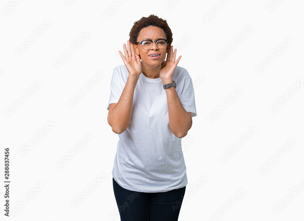 Beautiful young african american woman wearing glasses over isolated background Trying to hear both hands on ear gesture, curious for gossip. Hearing problem, deaf Beautiful young african american woman wearing glasses over isolated background Trying to hear both hands on ear gesture, curious for gossip. Hearing problem, deaf
