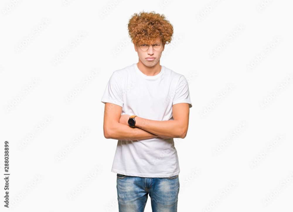 Young handsome man with afro hair wearing glasses skeptic and nervous, disapproving expression on face with crossed arms. Negative person. Young handsome man with afro hair wearing glasses skeptic and nervous, disapproving expression on face with crossed arms. Negative person.