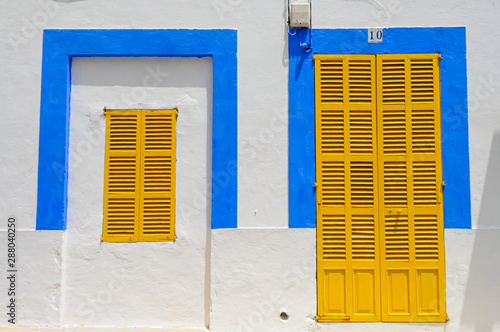 Yellow shutters closed over windows of a Spanish house