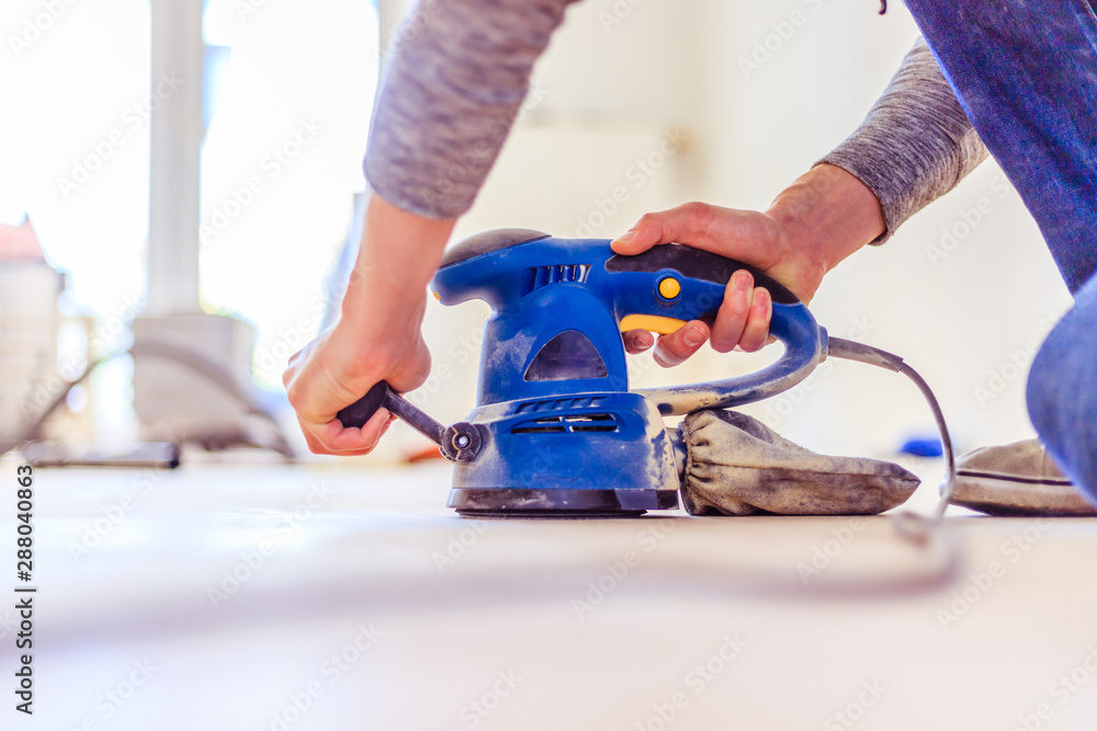 Renovating at home: sander tool for refreshing and grinding the wooden parquet floor