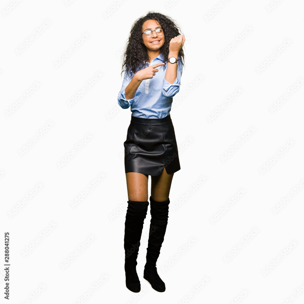 Fototapeta premium Young beautiful business girl with curly hair wearing glasses In hurry pointing to watch time, impatience, upset and angry for deadline delay