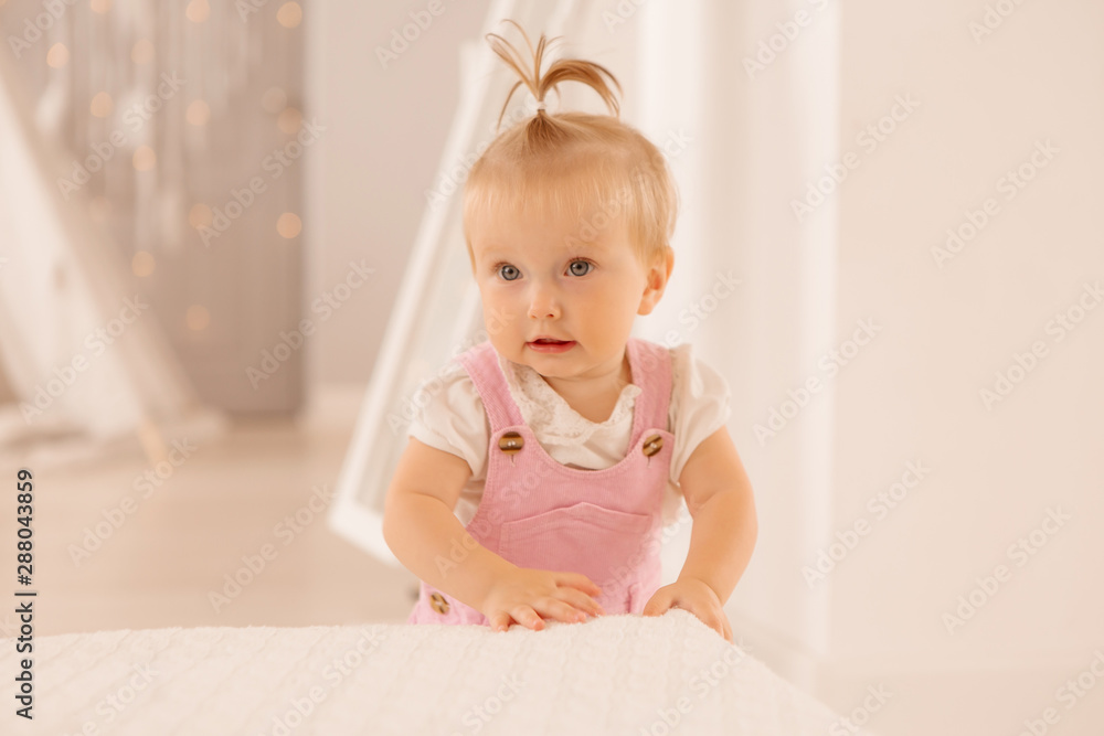 baby girl in the nursery playing,bright children's room, textiles for children's room baby girl in the nursery playing,bright children's room, textiles for children's room