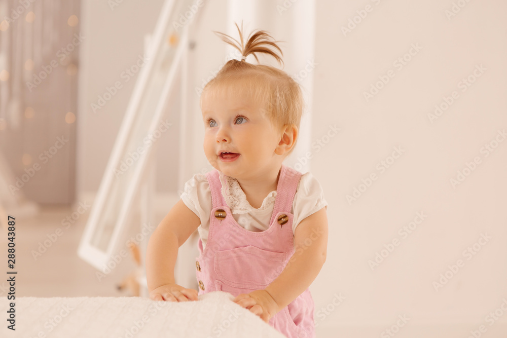 baby girl in the nursery playing,bright children's room, textiles for children's room