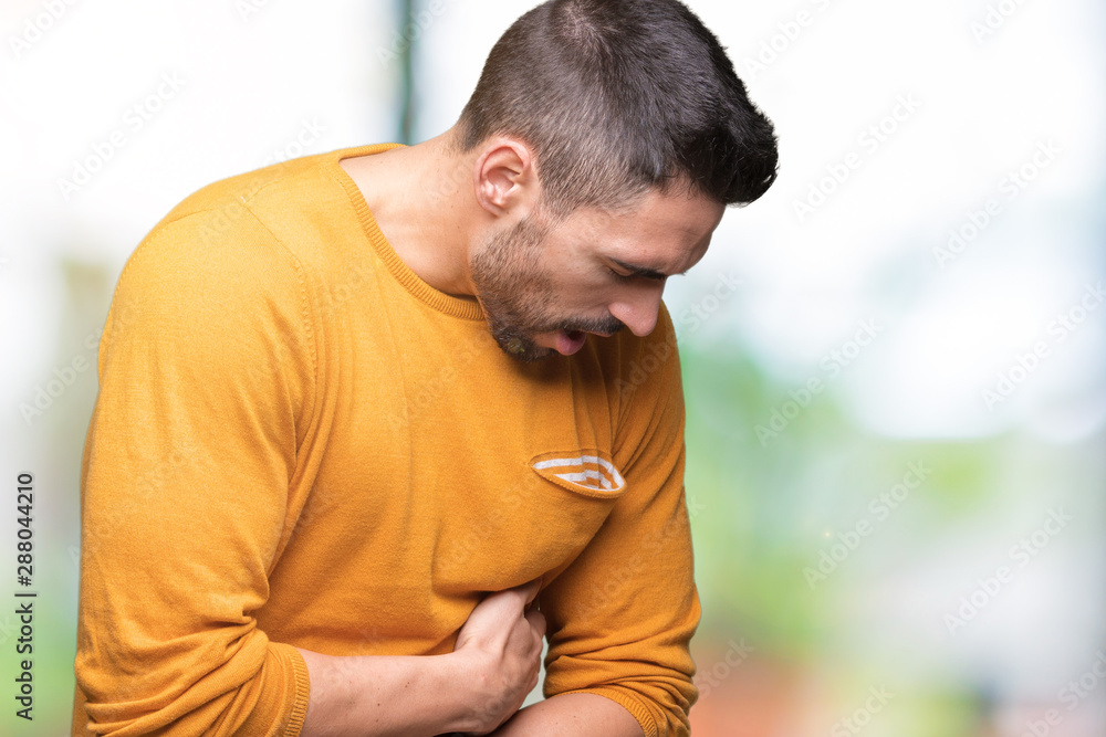 Young handsome man over isolated background with hand on stomach because nausea, painful disease feeling unwell. Ache concept. Young handsome man over isolated background with hand on stomach because nausea, painful disease feeling unwell. Ache concept.