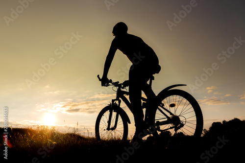 Bicycle man silhouette at sunset.